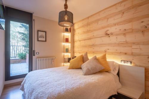 a bedroom with a large bed with a wooden wall at UNIQUE 57m2 Terraza BBQ magica vista Quer in Canillo