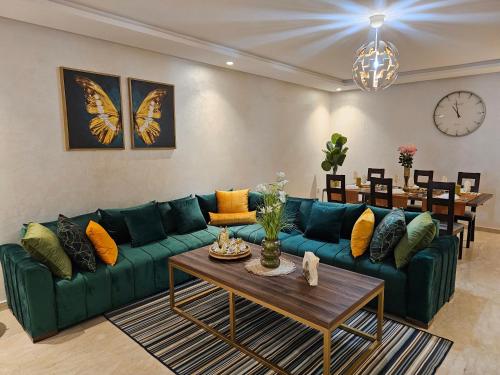 a living room with a green couch and a table at Genius 3 Bedroom Apartment with Beautiful Terrace Space, Casablanca in Casablanca