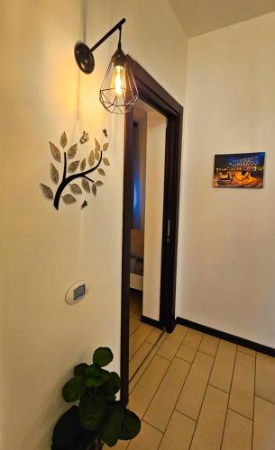 a hallway with a light and a plant in a room at AK Homes, a due passi da Orio in Azzano San Paolo