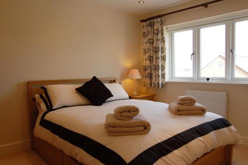 a bedroom with a bed with two towels on it at Sunset Bay Beach House in Tywyn in Tywyn