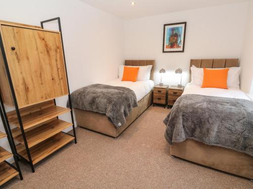 a bedroom with two beds and a mirror at Tredarn in Hayle