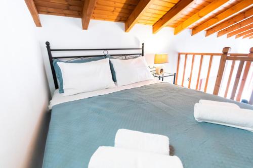 a bedroom with a blue bed with white pillows at YIAYIA's Central Apartment in Symi