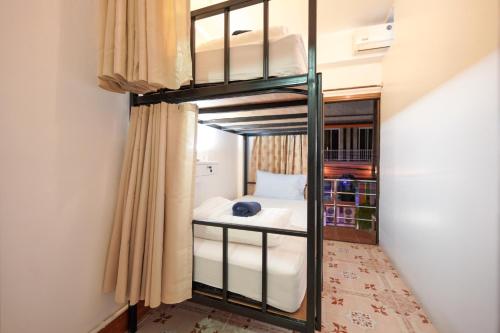 a bedroom with a bunk bed in a room at Baan Kamala Backpacker in Kamala Beach