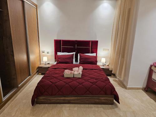 a bedroom with a red bed with two candles on it at 3 Bedroom Luxury Apartment with Premium Amenities for Larger Families in Casablanca