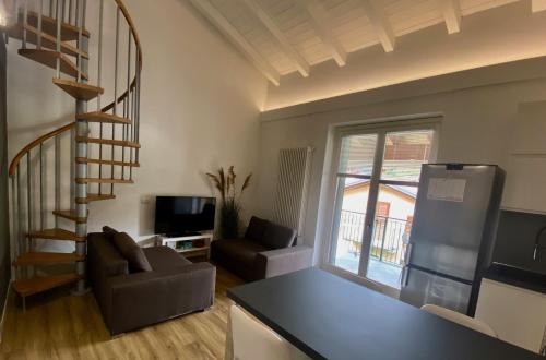 sala de estar con escalera de caracol y sala de estar en Modern apartment with terrace and mezzanine floor, en Colico