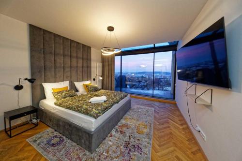 ein Schlafzimmer mit einem Bett und einem großen Fenster in der Unterkunft Exclusive maisonette above the park in Prag