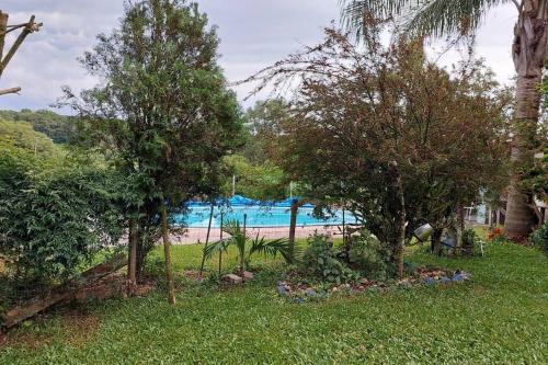 ogród z drzewami i basen w obiekcie Recanto do Descanso w mieście Caxias do Sul
