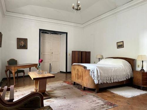 a bedroom with a bed and a table and a desk at Casa Histórica en Boyacá in Sogamoso