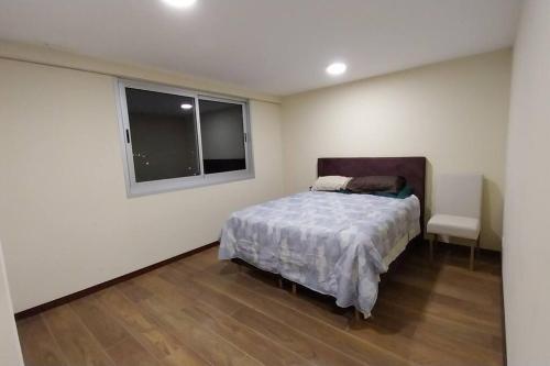 een slaapkamer met een bed en een raam bij Skyline Suites-Aventura de lujo in La Paz