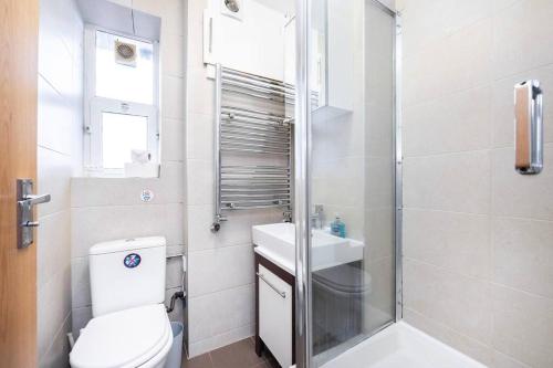 a bathroom with a shower and a toilet and a sink at Comfortable 2 Bedroom in Marylebone in London