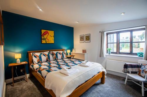 a bedroom with a bed and a blue wall at The Carriage House a relaxing 1-Bed Cottage in Ash in Ash