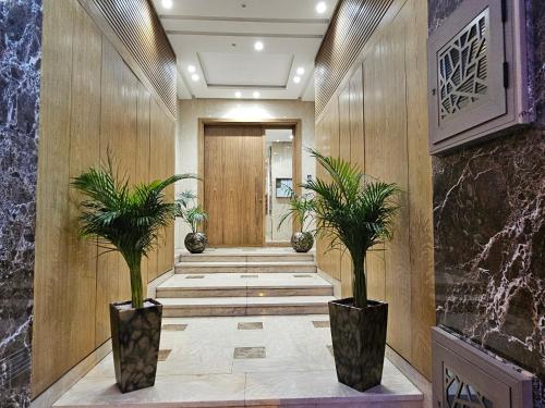 a hallway with two potted plants in front of a door at 3 Bedroom Luxury Apartment with Premium Amenities for Larger Families in Casablanca