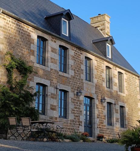 a brick building with two benches in front of it at La Thérèsienne in Pleines-Oeuvres