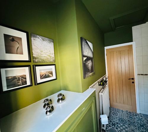 een badkamer met een wastafel en een groene muur bij Overleigh Cottage, with optional Hot Tub hire in Chester