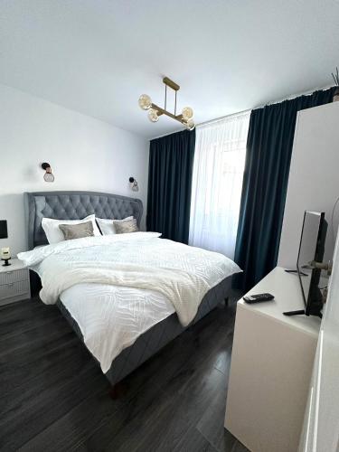 a bedroom with a bed and a desk with a computer at Evelyn Apartment in Bistriţa