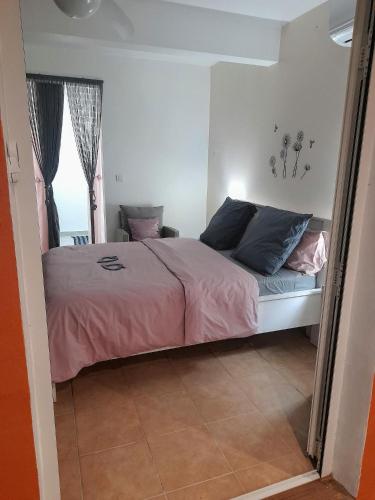 a bedroom with a bed with pink sheets and a window at Les Bromélias chez Djo et Rosy in Sainte-Marie