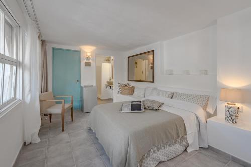 a white bedroom with a bed and a mirror at La Finquita - Adeje in Adeje