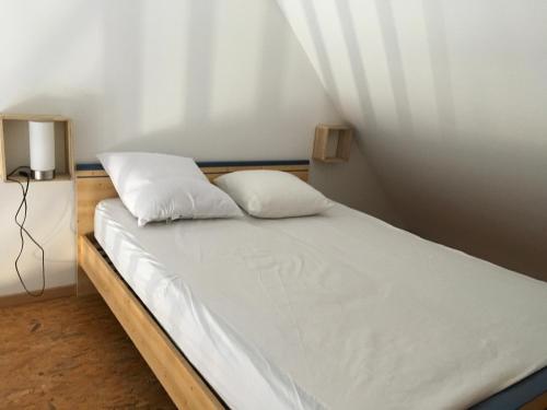 1 cama con 2 almohadas en una habitación en Roses des sables, en Jullouville-les-Pins