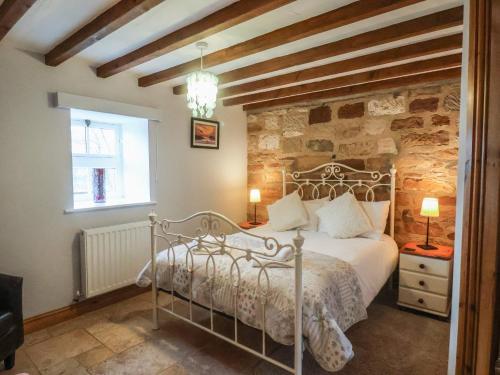 a bedroom with a bed and a stone wall at The Barn in Saltburn-by-the-Sea