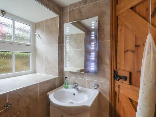 uma casa de banho com um lavatório e um espelho em The Barn em Saltburn-by-the-Sea
