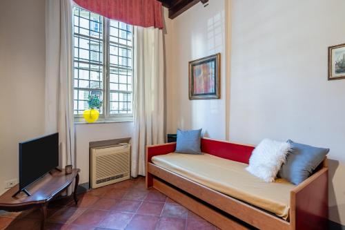 ein Wohnzimmer mit einem Sofa und einem TV in der Unterkunft San Pietro Somaldi Apartment in Lucca