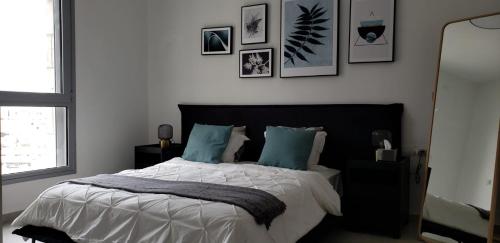 1 dormitorio con 1 cama grande con almohadas azules en Brand New 3 Bedroom Apartment in Shalem Tower, en Jerusalén