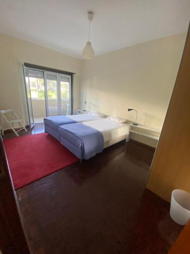 a bedroom with a large bed and a red rug at Casa Encantada - Benfica in Lisbon
