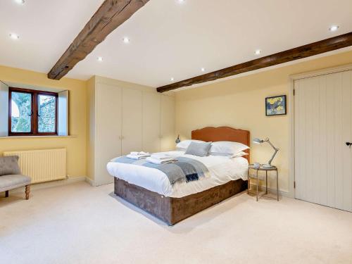 a bedroom with a large bed and a chair at 3 Bed in Kirkby Stephen 93379 in Orton