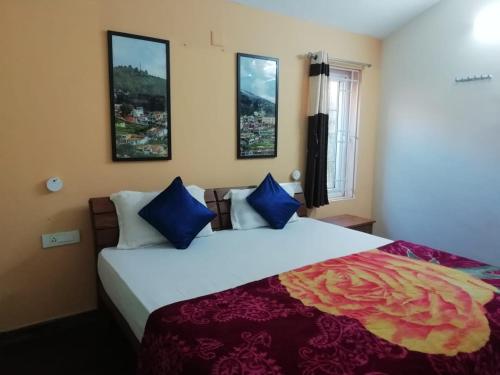 sypialnia z dużym łóżkiem z niebieskimi poduszkami w obiekcie Crystal homestay w mieście Utakamand