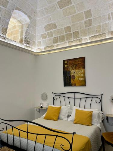 ein Schlafzimmer mit einem großen Bett mit gelben Kissen in der Unterkunft Bien-être Exclusive Apartment in Taranto