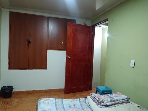 Habitación con armario, cama y puerta en Alojamiento Don Luis, en Popayán