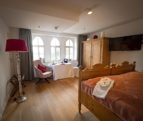 Schlafzimmer mit einem Bett, einem Tisch und einem Fenster in der Unterkunft Hotel Burg Abenberg in Abenberg