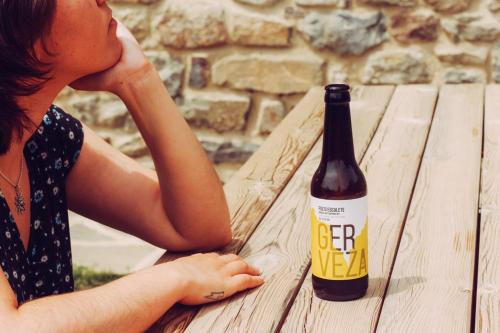 a woman sitting next to a bottle of beer on a picnic table at Casa Rural Ger in Yeste