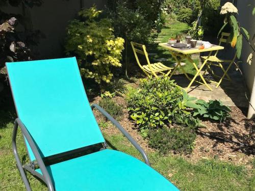 a blue chair and a table in a yard at Appartement cosy, indépendant avec jardin in Meudon