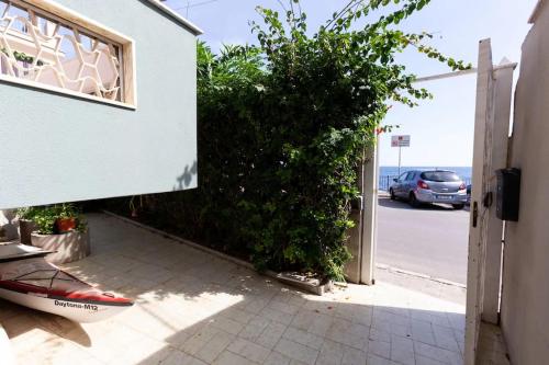 a door to a building with a car in a parking lot at Villa Emilia Mondello Appartamento Emily con vista sul mare in Palermo