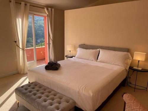 um quarto com uma grande cama branca e uma janela em Grande villa de 8 chambres avec piscine et tennis em Tourrettes-sur-Loup