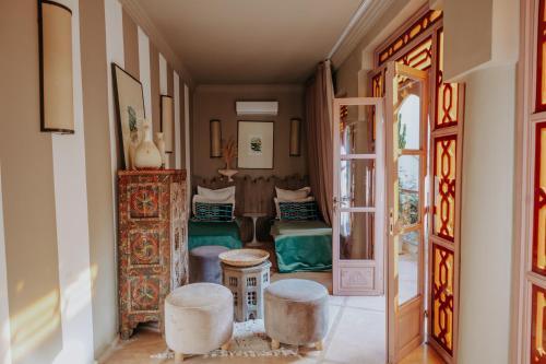 a hallway with two stools and a living room at Riad 117 in Marrakesh