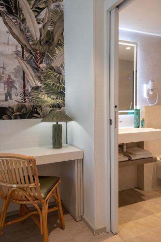 La salle de bains est pourvue d'un bureau et d'un miroir. dans l'établissement Résidence Hôtelière Chambord au coeur de Menton - entièrement rénovée, à Menton