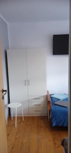 a bedroom with a bed and a chair and a table at Agroturystyka U Baltazara in Duszniki Zdrój