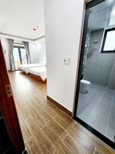 a bedroom with a bed and a bathroom with a shower at Happy Bun Hotel Da Lat in Da Lat