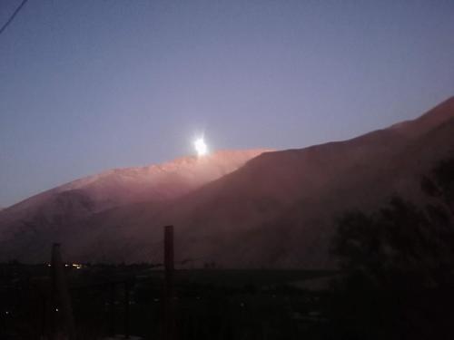 góra ze słońcem siedzącym na niej w obiekcie Hostal Acuariano Piscoelqui w mieście Pisco Elqui