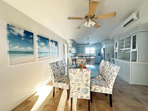a dining room with a table and chairs and the ocean at A'Viva Grace Bay - Alta3 in The Bight Settlements