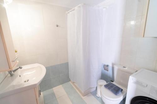 YIAYIA's Central Apartment في سيمي: حمام مع مرحاض ومغسلة ودش