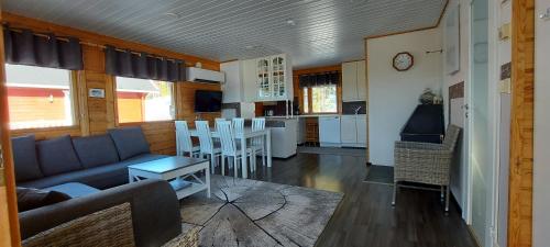 a living room with a couch and a kitchen at Hallan Alpit A mökki in Hyrynsalmi
