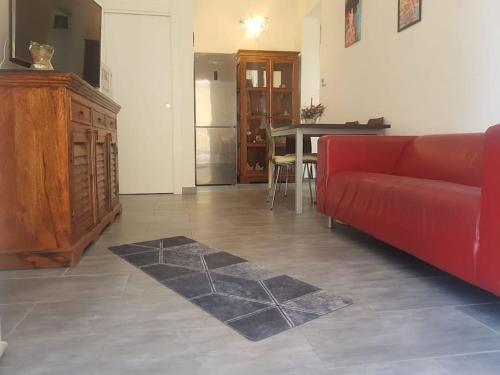 sala de estar con sofá rojo y mesa en Toni di Rosa, Tavullia centro, en Tavullia