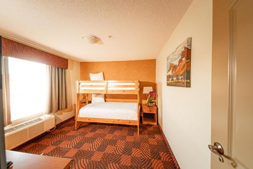 ein Schlafzimmer mit einem Etagenbett in einem Zimmer in der Unterkunft Service Plus Inns and Suites Calgary in Calgary