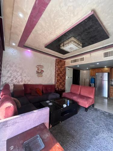 een woonkamer met een bank en een tafel bij Tarawneh & Thawabi in Amman