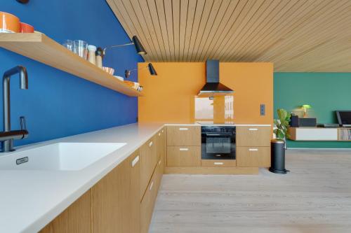 a kitchen with blue and yellow walls and a sink at Unique gem overlooking the world famous Bryggen in Bergen