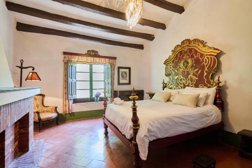 ein Schlafzimmer mit einem großen Bett und einem Kamin in der Unterkunft Villa Masía Blanca in Comarruga