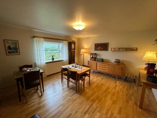 sala de estar con mesa, sillas y ventana en Litla-Sandfell Guesthouse, en Stóra-Sandfell